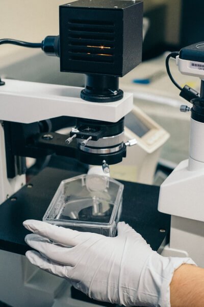 About Us diagnostic lab hand with glove holding tools